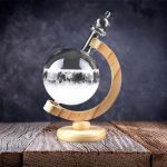 Orologio decorativo in stile scientifico con sfera di vetro e liquido, montato su base di legno, perfetto come oggetto di arredamento originale e ispirato alla scienza.