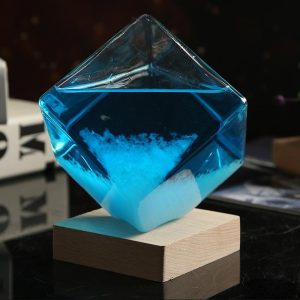 Vaso di cristallo trasparente con liquido blu e cristalli di sale, posizionato su base di legno, decorazione scientifica elegante e moderna.