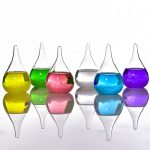 Vasi di vetro colorati con liquidi di diversi colori, riflessi su superficie lucida, decorazioni scientifiche e artistiche.