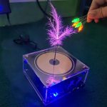 Punto 2: Dispositivo di laboratorio con piante fluorescenti e luci LED colorate, ideale per decorazioni scientifiche e attività educative.