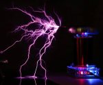 Scarica elettrica visibile con fulmini viola in laboratorio, con apparecchiature scientifiche e generatori di Tesla.