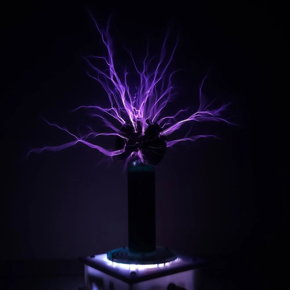 Modello di pila di Tesla con scariche di plasma viola che si irradiano verso l'alto, creando un effetto visivo impressionante e futuristico.