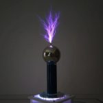 Modello di pila di Tesla con scarica di fulmini blu, mostra un effetto di elettricità statica e energia elettrica in un ambiente scuro.