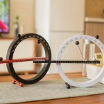 Due orologi scientifici con calendario perpetuo, uno nero e uno bianco, posizionati su un tavolo in un ambiente domestico. Ideali come decorazioni educative e oggetti da collezione.