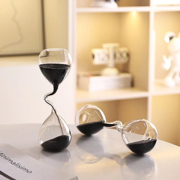 Orologio a clessidra decorativo in vetro con sabbia nera, oggetto di design per decorazioni scientifiche e da scrivania, ideale per appassionati di scienza e arredamento originale.