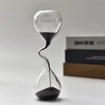 Clessidra decorativa con sabbia nera e trasparente, simbolo del tempo e della scienza, perfetta come oggetto decorativo o da collezione.