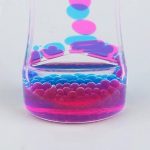 Pezzi di vetro colorati in un becher di laboratorio, decorazioni scientifiche per ambienti educativi e scientifici.