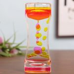Vaso trasparente con liquido colorato e bolle scientifiche, oggetto decorativo e educativo.