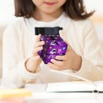 Bambino che gioca con un puzzle scientifico colorato, stimolando curiosità e apprendimento attraverso il gioco.