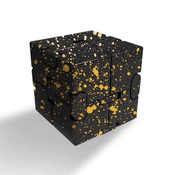 Cubo di Rubik decorativo nero con dettagli dorati a effetto splatter, perfetto come oggetto di design e decorazione scientifica.