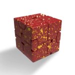 Cubo decorativo scientifico con superficie rossa e spruzzi dorati, perfetto come oggetto di design e decorazione per ambienti moderni e scientifici.
