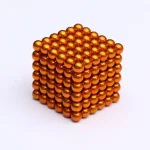 Modello di cubo composto da sfere metalliche arancioni disposte in modo ordinato, ideale come decorazione scientifica o oggetto da collezione.