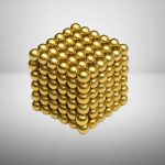 Modello di cubo 3D composto da palline di acciaio dorate, perfetto come decorazione scientifica o oggetto da collezione.