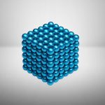 Palline blu metalliche disposte in un modello a cubo 3D, rappresentando una struttura molecolare o un oggetto decorativo scientifico.