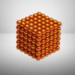 Pila di sfere di metallo dorate disposte a formare un cubo tridimensionale, perfetta come decorazione scientifica o oggetto da collezione.