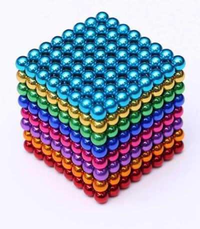 Cubo di magneti colorati in acciaio inossidabile, perfetto come decorazione scientifica o oggetto da scrivania, con sfondo bianco.