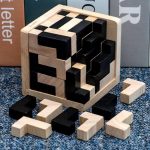Puzzle scientifico in legno e plastica con pezzi neri e naturali, ideale per decorazioni e giochi educativi. Perfetto per appassionati di scienza e design innovativo.