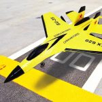 Aereo da addestramento militare di colore giallo con dettagli neri e rossi, posizionato su una pista di volo.