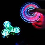 Fidget spinner luminoso con luci LED colorate, ideale come decorazione scientifica e oggetto di svago. Perfetto per appassionati di scienza e collezionisti di gadget innovativi.