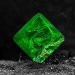 Pietra decorativa in vetro verde fluorescente con superficie lucida e trasparente, perfetta come oggetto decorativo scientifico o da collezione.