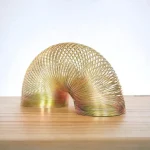 Scultura moderna in metallo dorato a forma di curva, decorativa e artistica, ideale per arredamento e collezionismo scientifico.