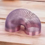 Tubo di metallo a spirale decorativo in rosa, perfetto come oggetto scientifico o decorativo, ideale per appassionati di scienza e design innovativo.