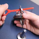 Strumento di precisione scientifica per esperimenti di fisica, con parti metalliche e componenti di plastica rossa, utilizzato per studi e dimostrazioni scientifiche.