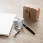 Orologio in legno con design minimalista e oggetti scientifici decorativi, ideale per appassionati di scienza e arredamento originale. Perfetto come complemento d'arredo per studi e ambienti di lavoro.