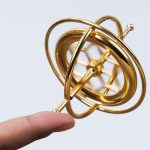 Modello di atomo in miniatura in metallo dorato, decorazione scientifica elegante e dettagliata, perfetta come oggetto decorativo o da collezione.