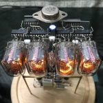 Modello di pianeta Terra in miniatura con tubi Nixie illuminati, rappresenta un oggetto decorativo scientifico con dettagli realistici e tecnologia vintage.