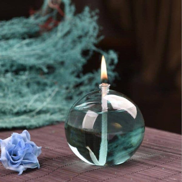 Oggetto decorativo in vetro a forma di pallina con candela accesa, ideale come decorazione scientifica o da tavolo.