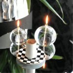 Vaso con caffè caldo e decorazione scientifica luminosa, composta da sfere di vetro con fiamme artificiali, su base decorativa a scacchi. Perfetto come oggetto decorativo e da collezione scientifica.
