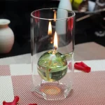 Oggetto scientifico: pallone di vetro con liquido infiammabile e fiamma accesa, utilizzato per esperimenti di chimica e fisica.