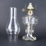 Oggetto scientifico in vetro e metallo, probabilmente parte di un esperimento o di un dispositivo di laboratorio, con design vintage e dettagli tecnici visibili.