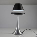 Lampada da tavolo moderna con base in metallo e paralume nero, ideale come decorazione scientifica o elemento di design per ambienti contemporanei.