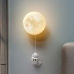 Luce notturna a forma di luna con astronauta decorativo, perfetta come lampada da notte o elemento decorativo a tema spaziale per bambini e adulti.