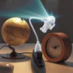 Lampada da tavolo a forma di astronauta che proietta luce su un globo terrestre, ideale come decorazione scientifica e oggetto di studio per appassionati di astronomia e scienze.