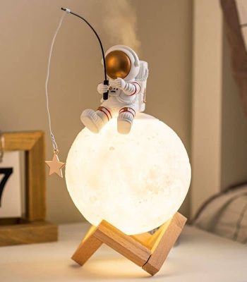 Luce da notte decorativa con astronauta che pesca dalla luna, perfetta per ambienti scientifici o per gli appassionati di spazio.