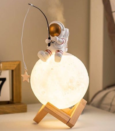 Luce da notte decorativa con astronauta che pesca dalla luna, perfetta per ambienti scientifici o per gli appassionati di spazio.