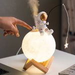 Lampada decorativa a forma di pianeta Terra con astronauta in miniatura, perfetta come oggetto di arredamento scientifico e decorativo.