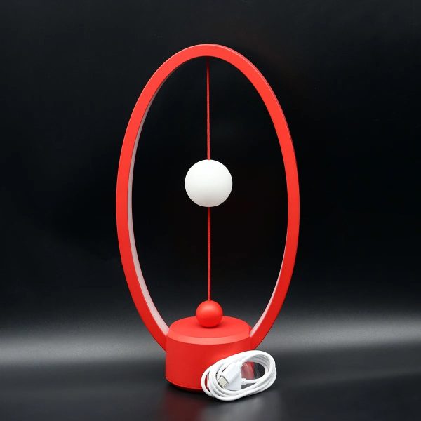 Orologio scientifico con struttura rossa e sfere bianche, ideale come decorazione da scrivania o oggetto di design ispirato alla scienza.