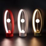 Pendo luminoso scientifico con sfere sospese in tre colori, decorazione moderna e originale per ambienti di studio o ufficio.