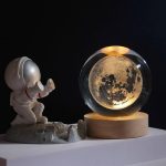 Decorazione con luna in cristallo trasparente e base in legno, perfetta come oggetto decorativo scientifico.