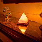 Piramide luminosa decorativa in vetro opaco con luce calda, ideale come oggetto di arredamento e decorazione scientifica per ambienti moderni e accoglienti.