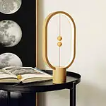 Orologio decorativo ispirato a un esperimento scientifico con sfere dorate e design moderno, perfetto come oggetto di decorazione per ambienti studi e spazi creativi.