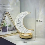 Luce decorativa a forma di luna con base dorata, realizzata in cristallo trasparente con dettagli incisi, altezza di 19,5 cm e larghezza di 10 cm, perfetta come decorazione scientifica o oggetto di de.