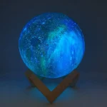 Palla luminosa decorativa a tema galattico con effetti di luce blu e verde, perfetta come oggetto scientifico o decorazione per ambienti educativi e moderni.