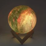 Luna 3D illuminata con dettagli realistici, mostra crateri e superfici irregolari, posizionata su supporto in legno, perfetta come decorazione scientifica.