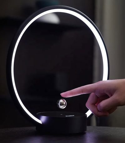 Lampada decorativa con anello luminoso LED e sfera galleggiante, perfetta come oggetto di design e decorazione scientifica moderna.