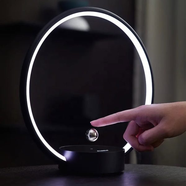 Lampada decorativa con anello luminoso LED e sfera galleggiante, perfetta come oggetto di design e decorazione scientifica moderna.